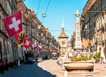 Altstadt von Bern, mit einem Brunnen, der Zytglogge und vielen bunten Flaggen