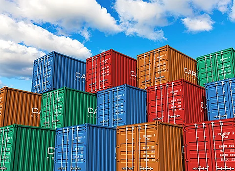 Schiffscontainer in verschiedenen Farben, im Hintergrund ein blauer Himmel mit Wolken