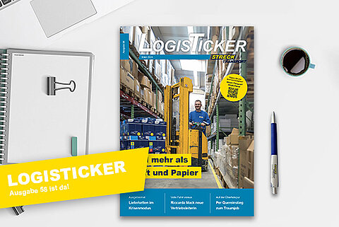 Die 58. Ausgabe der Streck Transport-Kundenzeitschrift LogisTicker liegt auf einem Schreibtisch mit Kugelschreiber, Notizblock und Kaffeetasse
