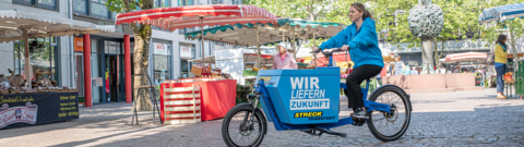 Eine Mitarbeiterin von Streck Transport fährt auf dem Lastenrad in der Lörracher Innenstadt