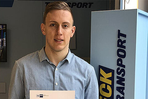Der Auszubildende Dominik Leonhardt hält eine Urkunde der IHK für seine hervorragenden Leistungen