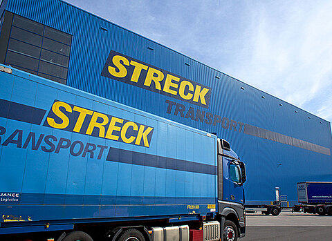 Lkw von Streck Transport fährt auf dem Betriebsgelände Freiburg vor der Blauen Halle