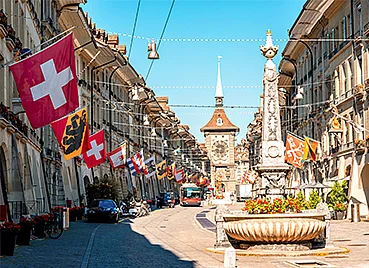 Altstadt von Bern, mit einem Brunnen, der Zytglogge und vielen bunten Flaggen