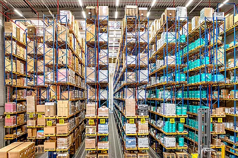 Die Regalreihen des Hochregallagers von Streck Transport in Freiburg sind gefüllt mit Fässern, Paletten und sonstigen Waren