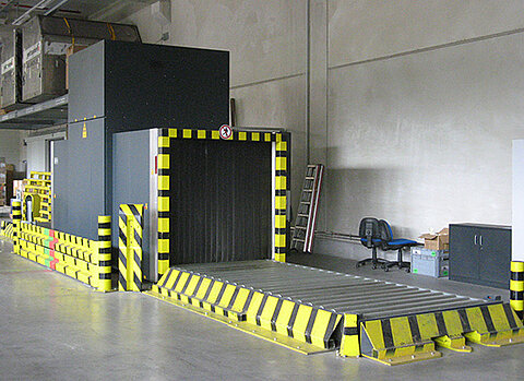 Frachtröntgenanlage für Luftfracht und Seefracht am Standort Freiburg, diese ist grau lackiert und mit gelb-schwarzen Warnstreifen versehen