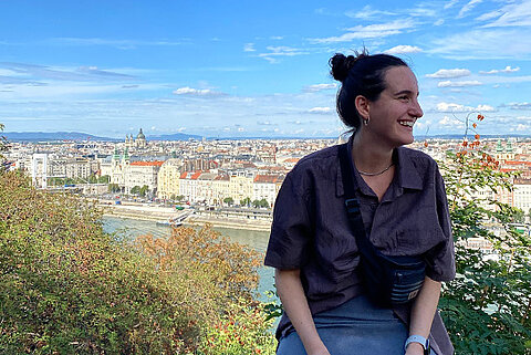 Auslandsaufenthalt Viola Wehrle Budapest Viola Wehrle, DHBW-Studentin bei Streck Transport, sitzt auf einer Anhöhe mit Blick auf die ungarische Hauptstadt Budapest