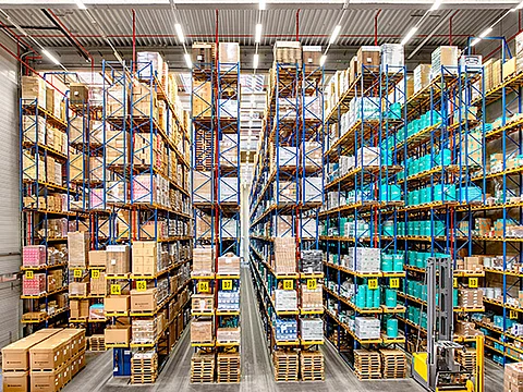 Die Regalreihen des Hochregallagers von Streck Transport in Freiburg sind gefüllt mit Fässern, Paletten und sonstigen Waren