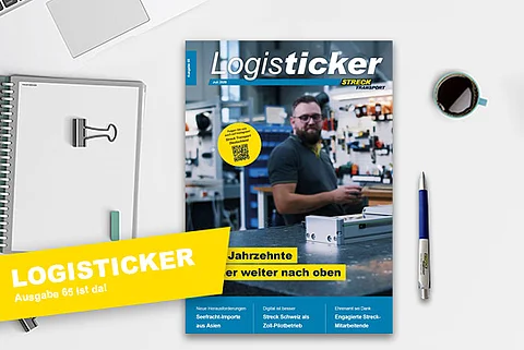 Die 65. Ausgabe der Streck Transport-Kundenzeitschrift LogisTicker liegt auf einem Schreibtisch mit Kugelschreiber, Notizblock und Kaffeetasse