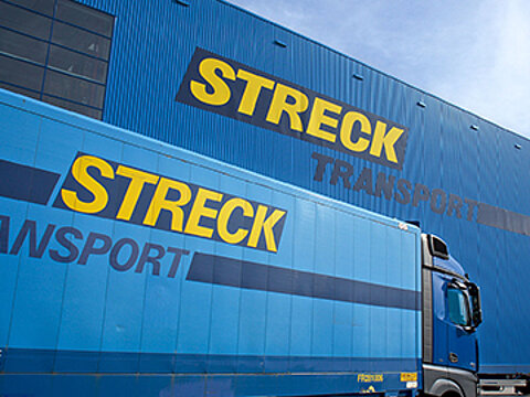 Lkw von Streck Transport fährt auf dem Betriebsgelände Freiburg vor der Blauen Halle