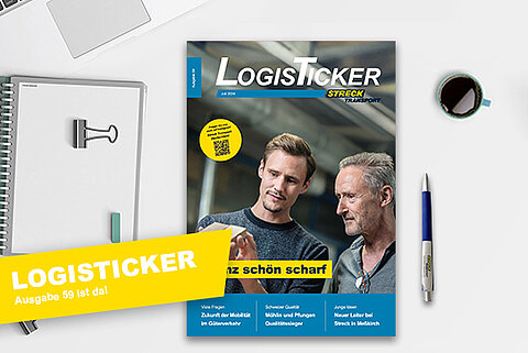 Die 59. Ausgabe der Streck Transport-Kundenzeitschrift LogisTicker liegt auf einem Schreibtisch mit Kugelschreiber, Notizblock und Kaffeetasse