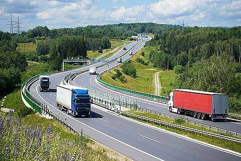 Lkws auf einer Autobahn passieren in beiden Richtungen eine Mautstelle