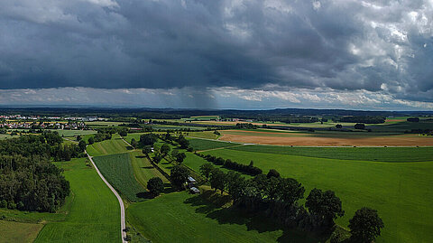 Luftaufnahme von Regengüssen hinter Altshausen, Oberschwaben