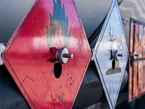 Drei Hinweisschilder auf Gefahrgüter an einem Tanklaster