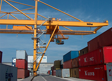 viele Container und ein Kran im Basler Rheinhafen bei blauem Himmel