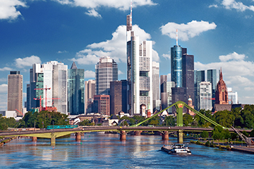 Skyline der Wolkenkratzer von Frankfurt am Main, im Vordergrund der Main mit einem Frachtschiff und einer Brücke